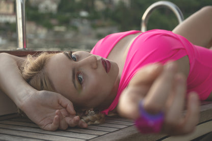 Model with macro of Lovran Love swimsuit in Pink Passion color by eco-sustainable brand Paraima Opatija